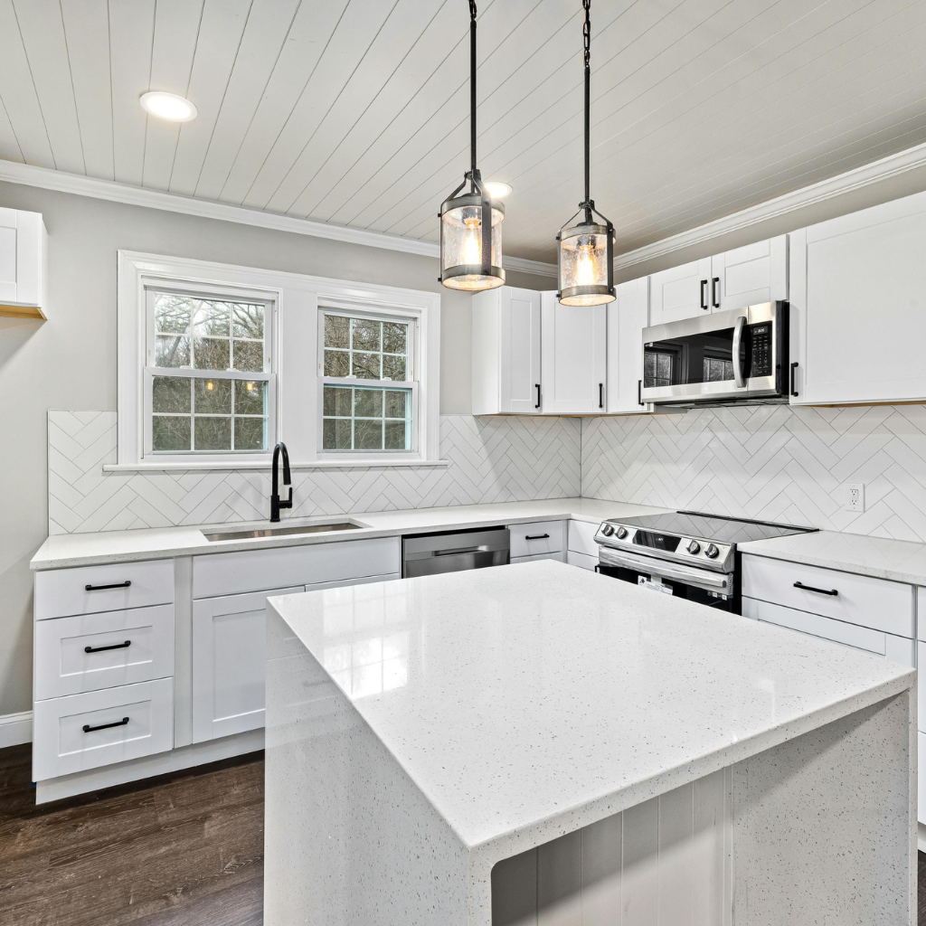 Modern open-concept kitchen remodel with white cabinets, island seating, and pendant lighting in Las Vegas home